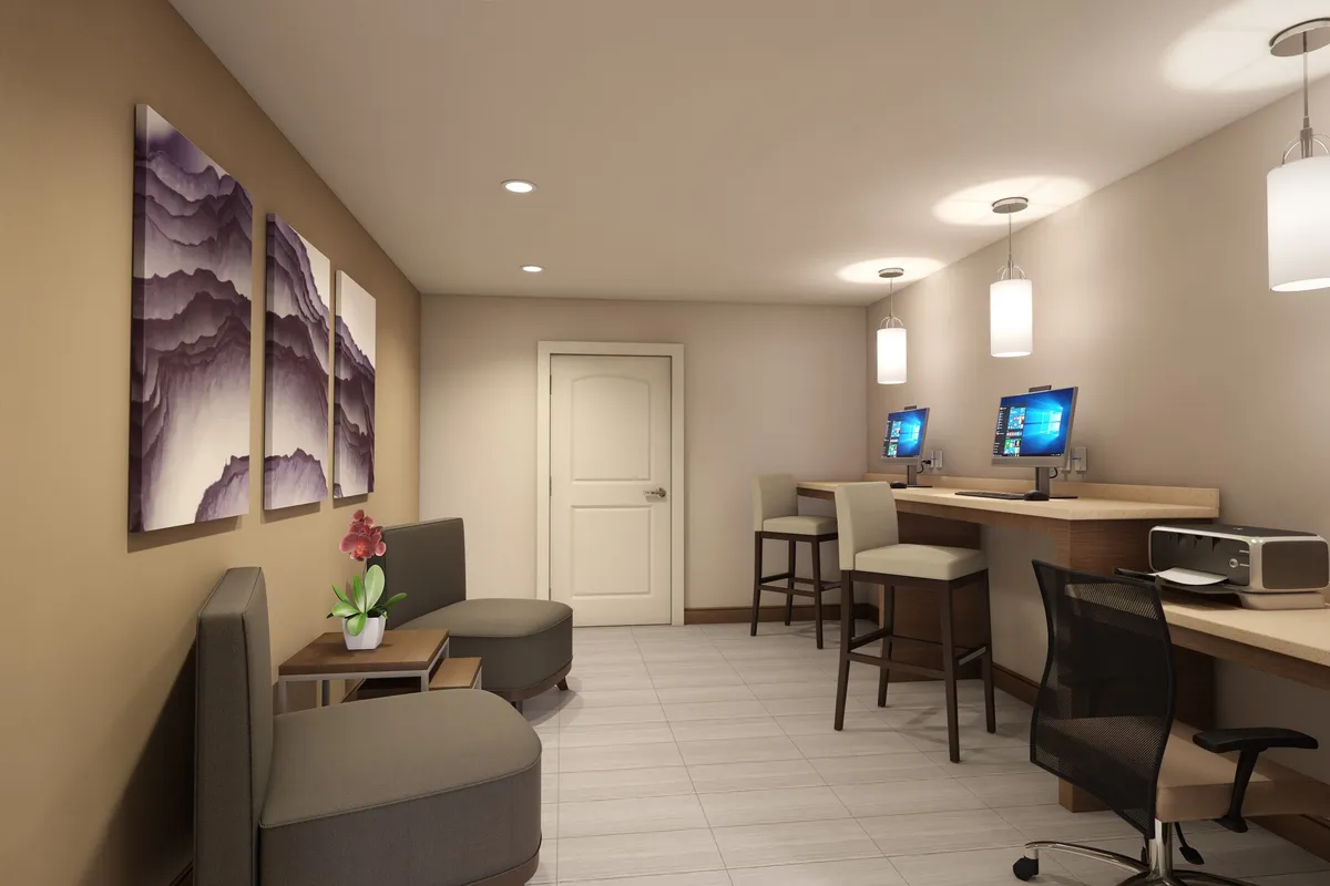 A contemporary workspace area within an interior setting, featuring abstract wall art, computer workstations, and a comfortable seating zone. The scene is designed for productive work or study sessions in an inviting atmosphere.