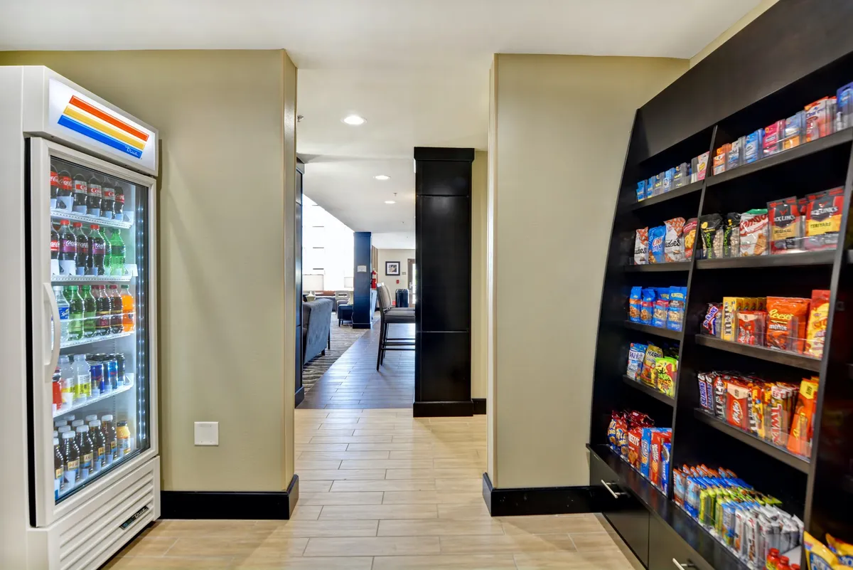 This image shows a snack and beverage fridge, neatly stocked and ready for guests, as part of the Providence Marketplace area. The display makes it easy for guests to grab local treats or quick refreshments, tying into the convenience of stocking up for in-suite meals or snacks.