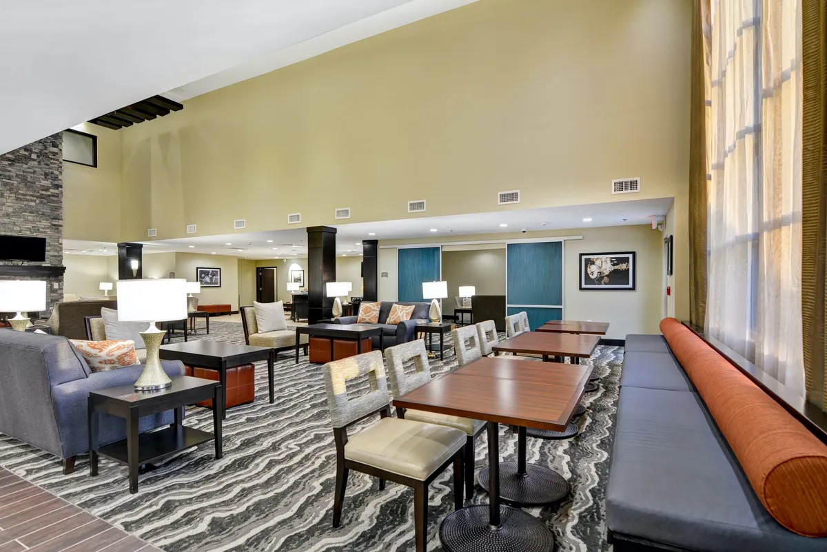 A comfortable lounge with plush seating, work-friendly tables, large windows letting in abundant natural light, and tasteful decorative artwork. The space feels inviting and flexible—suitable for relaxing, casual meetings, or remote work.